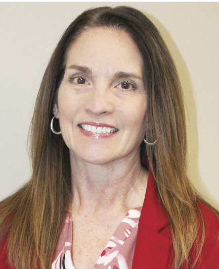 Tonya Barta; A woman with long brown hair smiles warmly, wearing a red blazer over a pink patterned blouse. She exudes a friendly and professional demeanor.